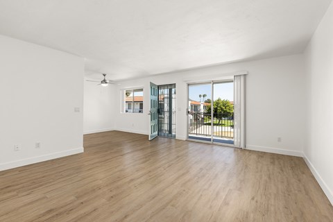 A room with a sliding glass door leading to a balcony.