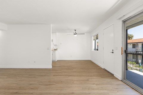 A room with a sliding glass door leading to a balcony.