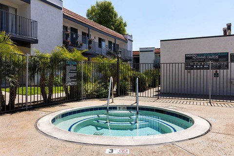 A pool with a warning sign in front of a building.