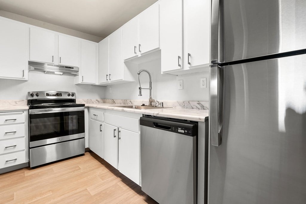 A modern kitchen with stainless steel appliances and white cabinets.