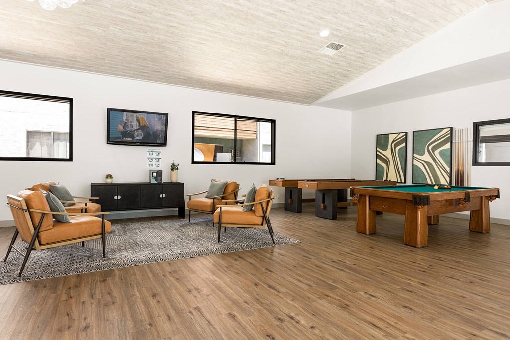 A living room with a black couch, a wooden coffee table, and a rug.