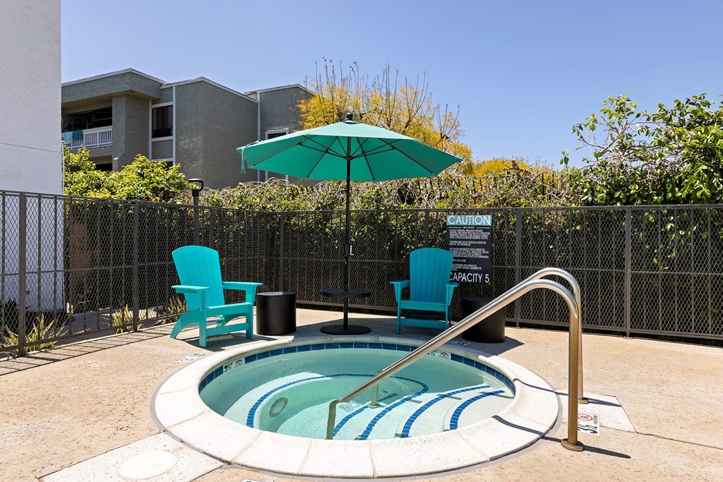 A small pool with a blue striped border and a metal fence surrounding it.