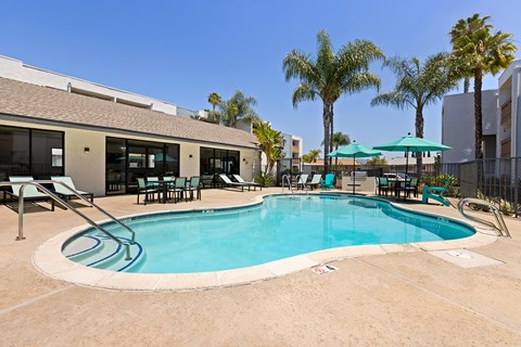 A swimming pool surrounded by chairs and umbrellas.