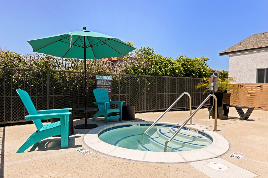 A small pool with a hot tub and two chairs.