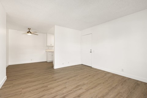 A room with a ceiling fan and wooden flooring.