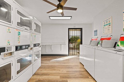 A row of white ovens are lined up in a kitchen.