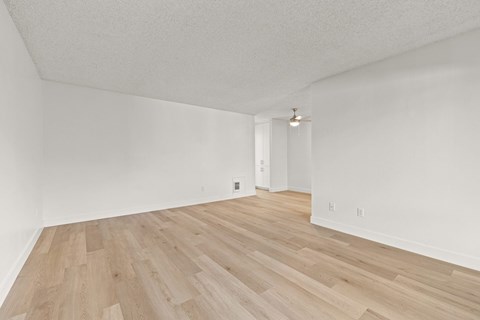 A room with wooden flooring and white walls.