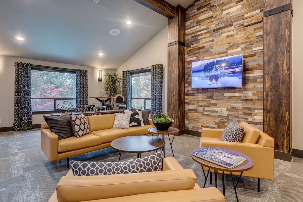 A living room with a stone wall and a television mounted on it.