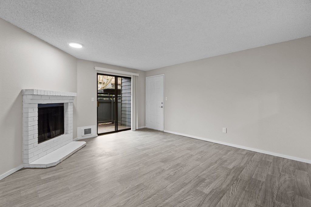 A room with a fireplace and sliding glass doors.