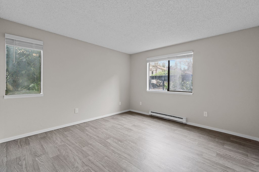 A room with a window and a picture on the wall.