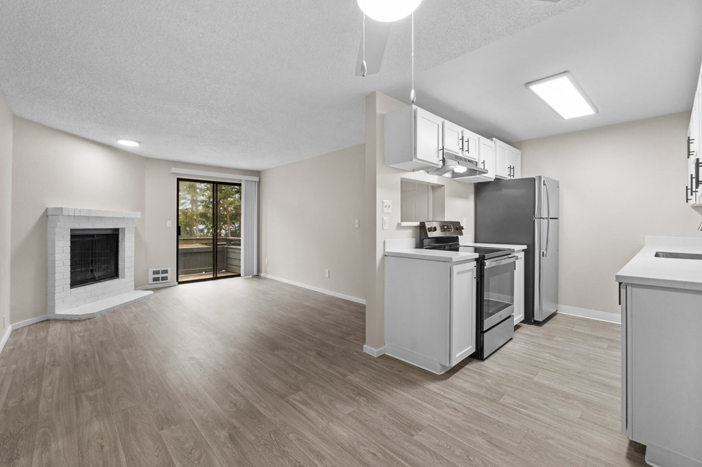 A spacious kitchen with white appliances and a fireplace.