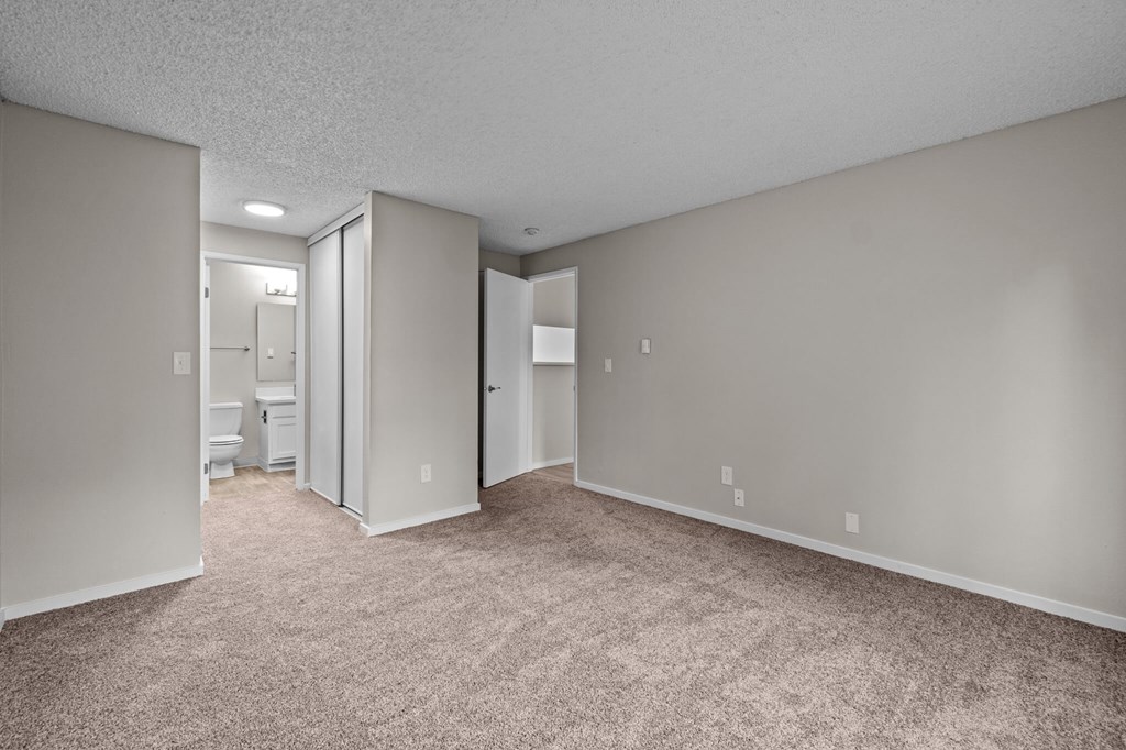 A spacious room with carpeted floor and white walls.