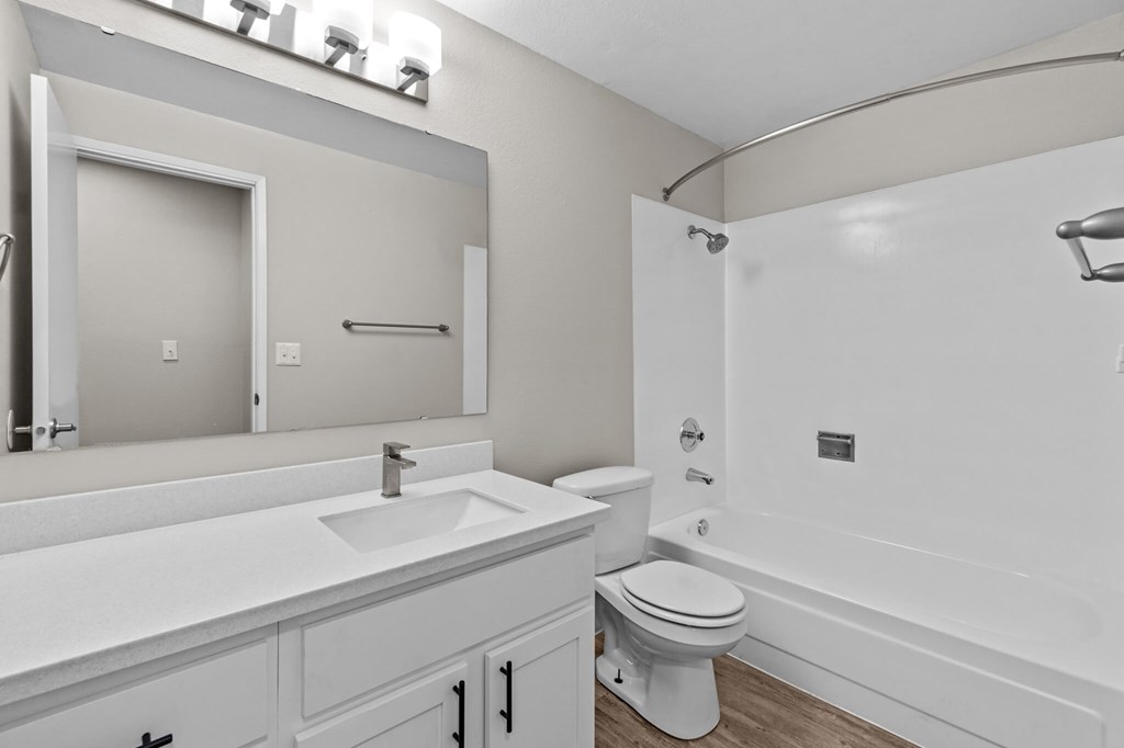 A white bathroom with a sink, toilet, and bathtub.