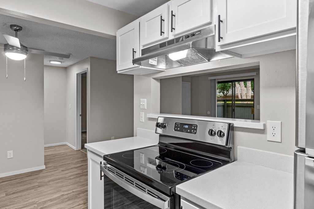 A modern kitchen with a stove top oven and a microwave above it.