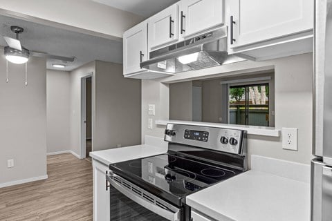 A modern kitchen with a stove top oven and a microwave above it.
