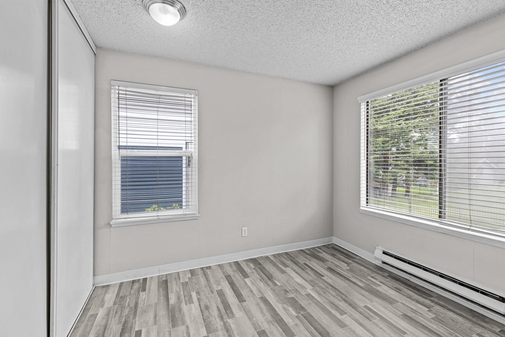 A room with a window and a wooden floor.