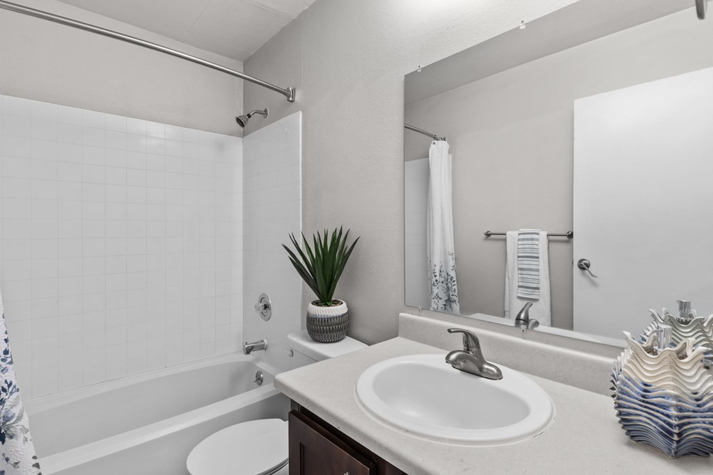 A bathroom with a white sink and a white toilet.