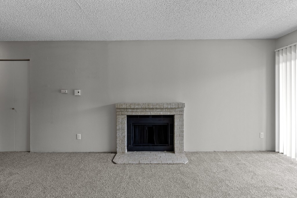 A fireplace in a room with a carpeted floor.