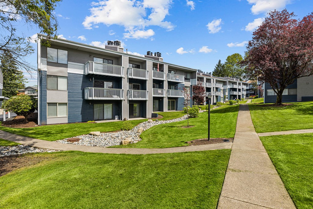 Apartment complex with a walkway in front.