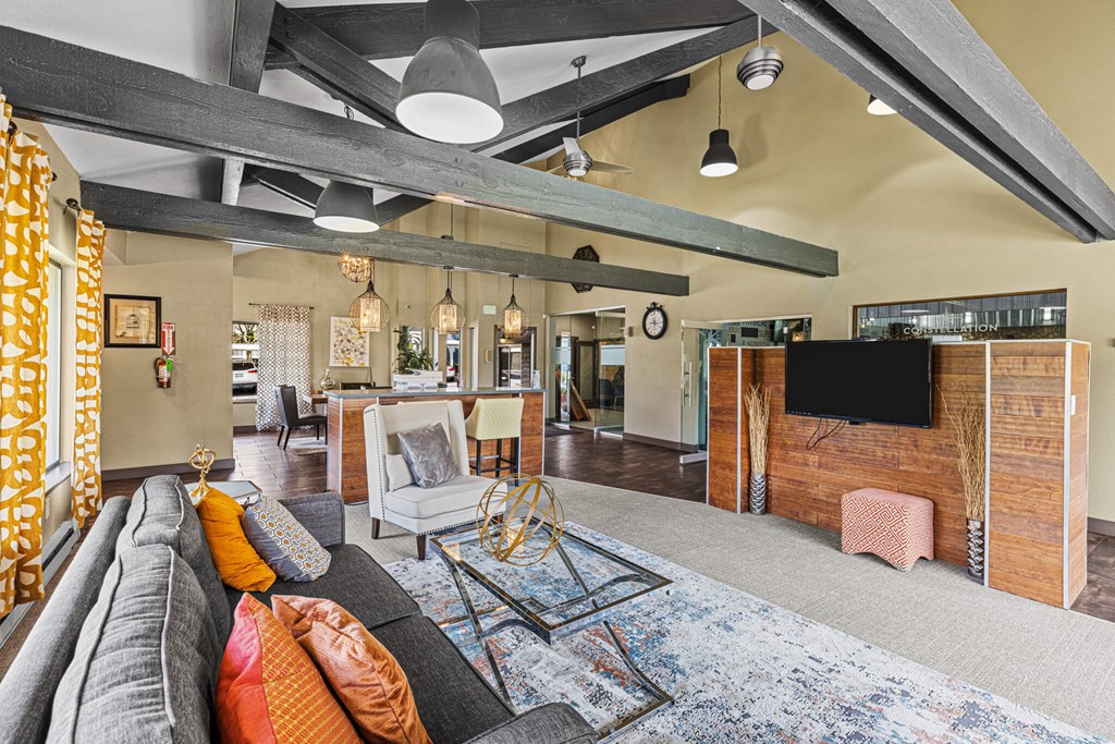 A living room with a grey couch and a wooden cabinet.