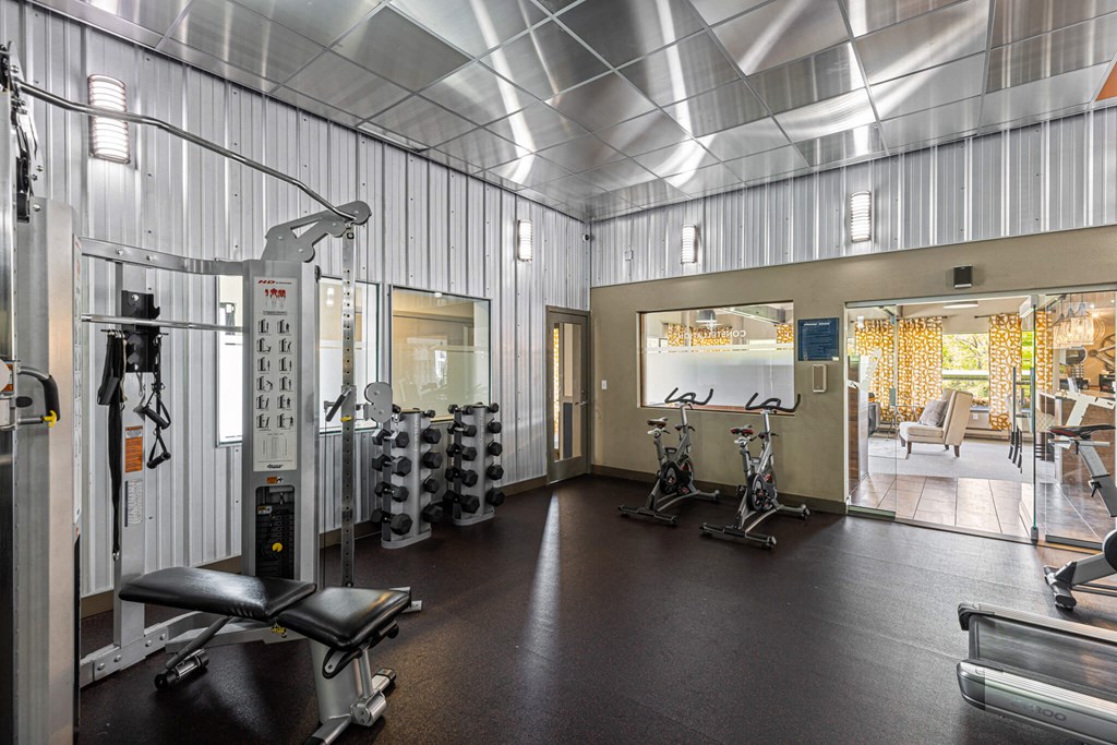 A gym with a variety of equipment including weights and cardio machines.