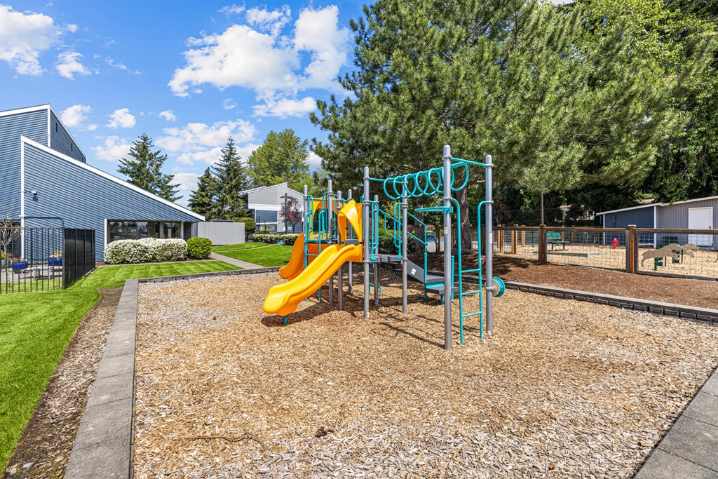 A playground with a yellow slide and a blue structure.