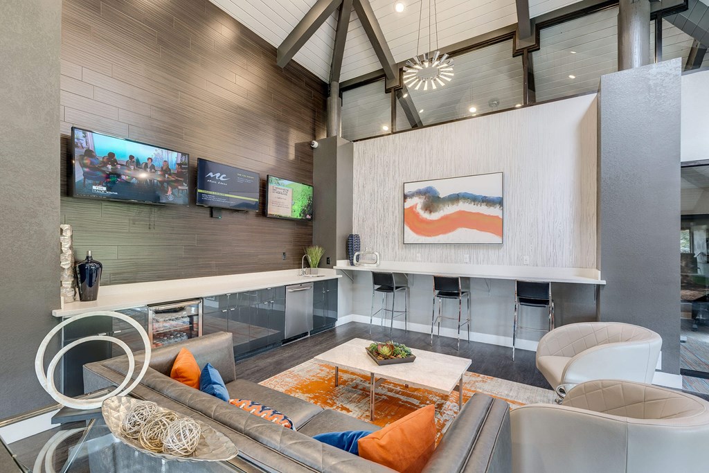 A modern living room with a glass coffee table and a large painting on the wall.