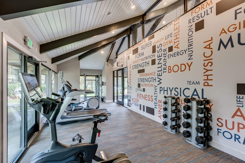A gym with a wall of words related to fitness and exercise.