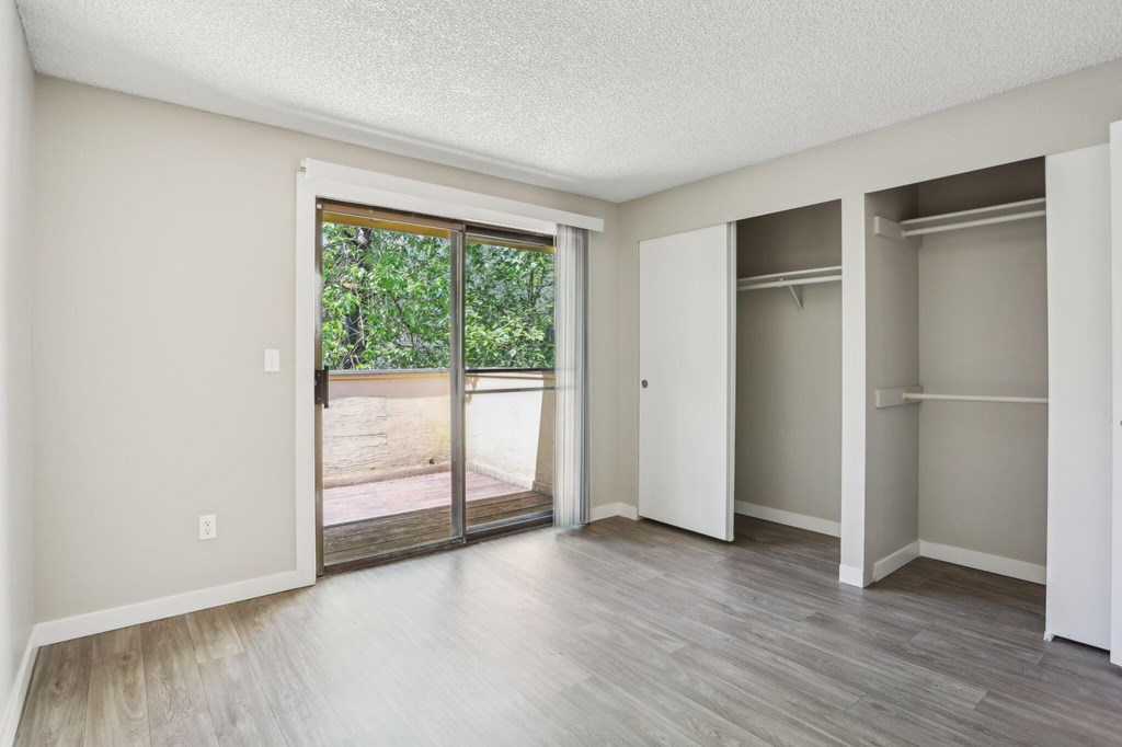 A room with a sliding glass door leading to a backyard.