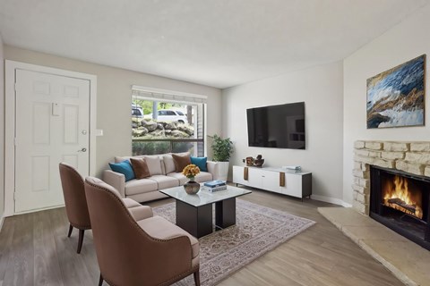 A living room with a fireplace and a television on the wall.