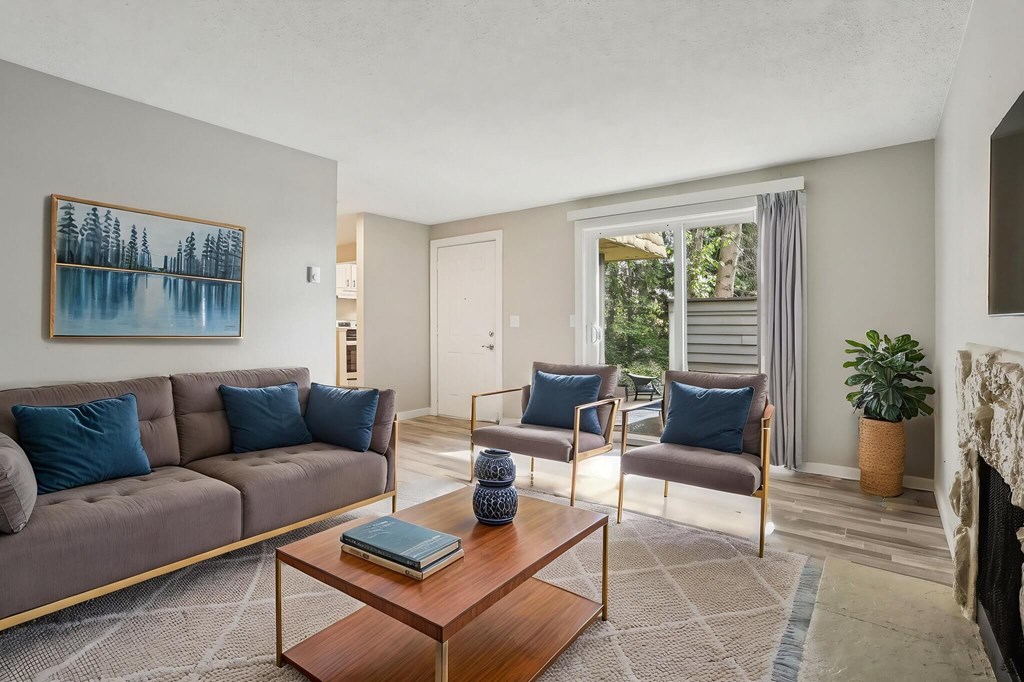A living room with a grey couch, a coffee table, and a painting on the wall.
