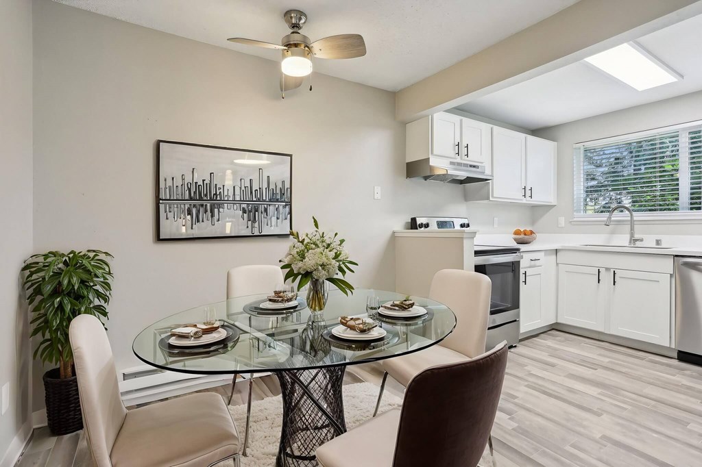 A modern dining room with a glass table and chairs.