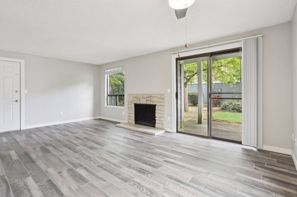 A room with a fireplace and sliding glass doors.