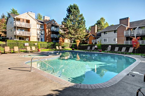 A swimming pool surrounded by a fence and buildings.