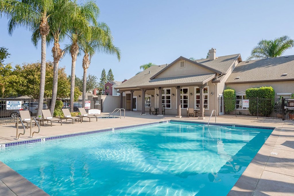 A large house with a pool in front.