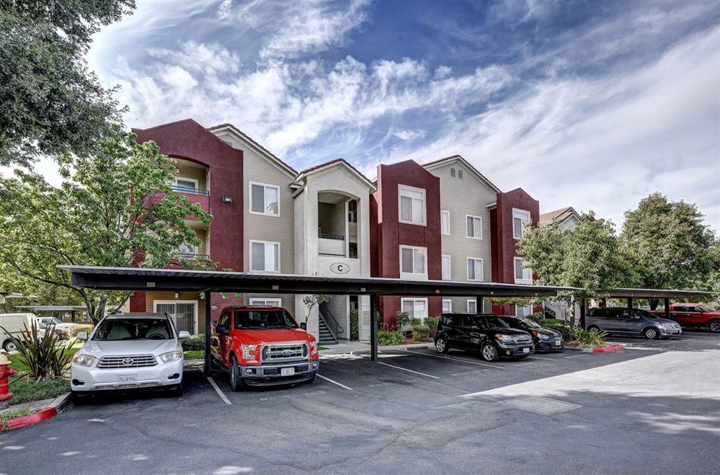 A parking lot in front of a red and white building.