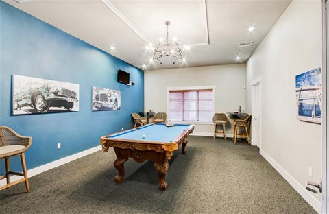 A room with a pool table and a chair.