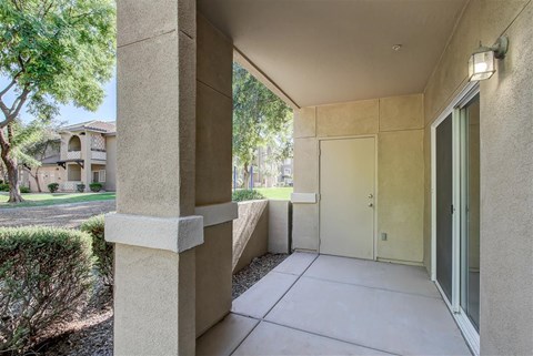 A building entrance with a door and a wall on the left.