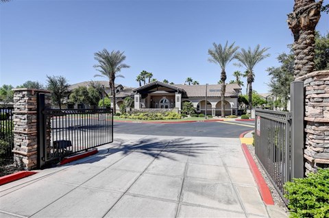 A gated entrance to a residential area with palm trees.