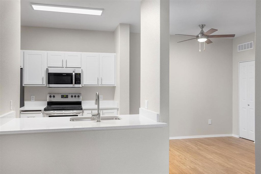 A modern kitchen with white cabinets and a stainless steel oven.