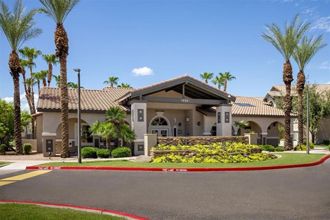 A building with a red roof and palm trees in front.