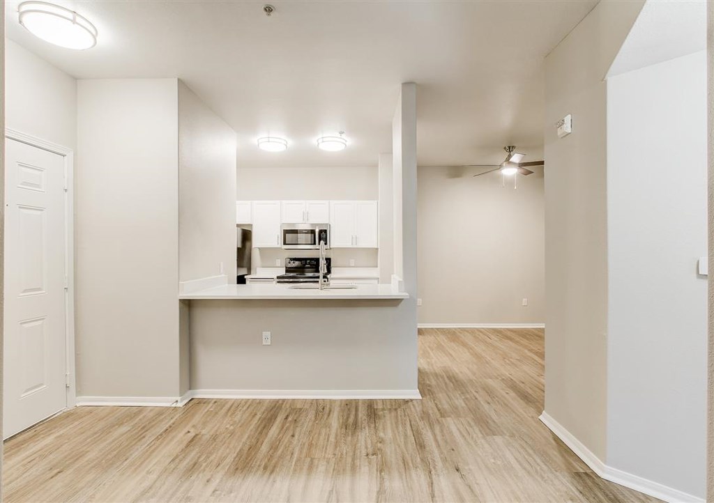 A white room with a counter and a microwave.