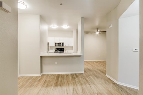 A white kitchen area with a microwave and oven built into a counter.