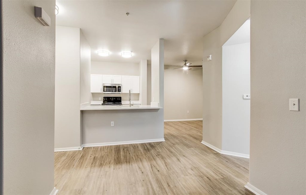 A kitchen area with a white countertop and a sink.