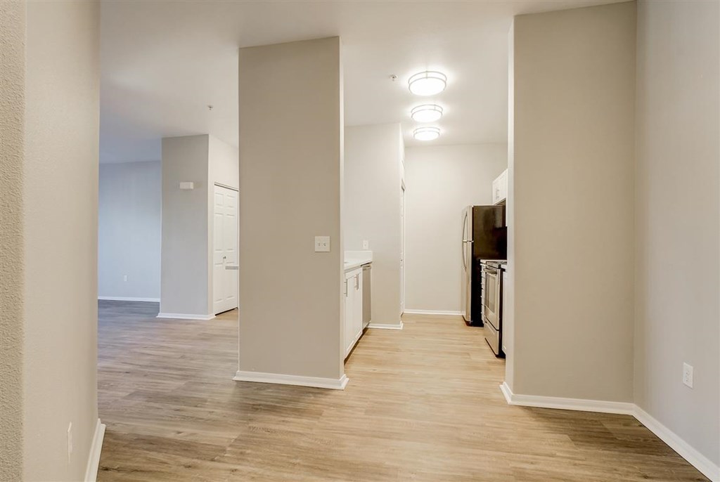 A kitchen area with a refrigerator, oven, and cabinets.