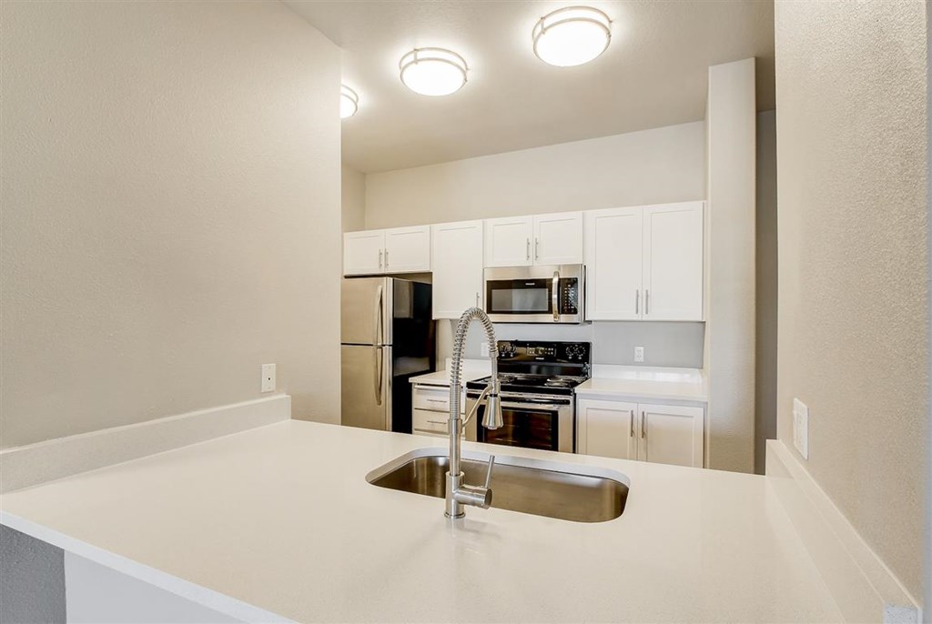 A kitchen with a sink and a refrigerator.