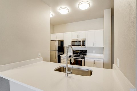 A kitchen with a sink and a refrigerator.