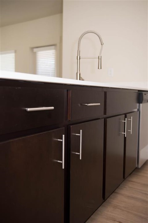 A kitchen with brown cabinets and a white counter.
