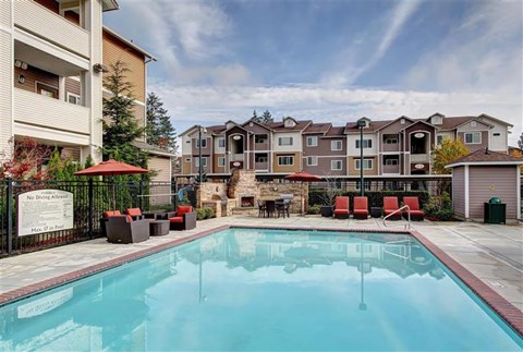 A swimming pool in front of apartment buildings.