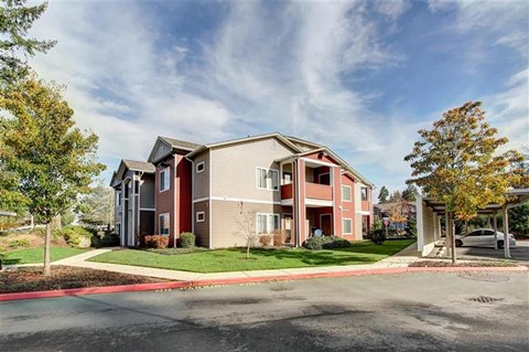 A large apartment complex with a parking lot in front.